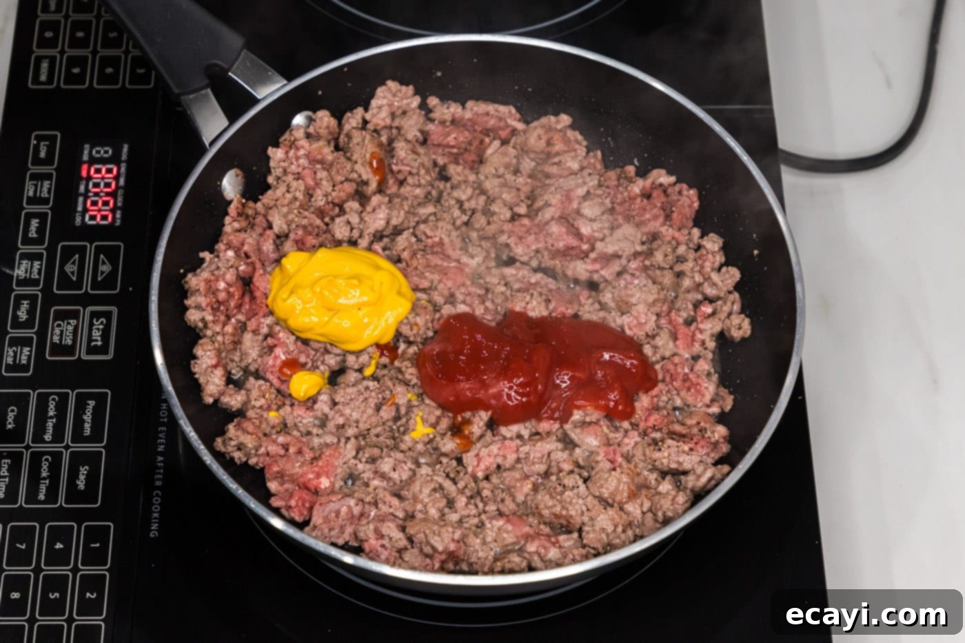 Ultimate Big Mac Egg Rolls 6 mustard and ketchup added to browned ground beef in skillet, being stirred