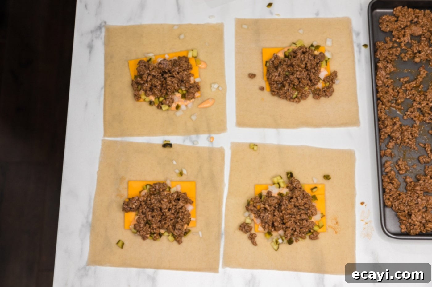 Ultimate Big Mac Egg Rolls 10 ground beef mixture placed on top of egg roll wrappers with cheddar cheese, onion, and pickles