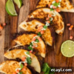 Hearty Black Bean Tacos 13 Close up photo of Black Bean Tacos on a wooden platter topped with sour cream, tomatoes and cilantro