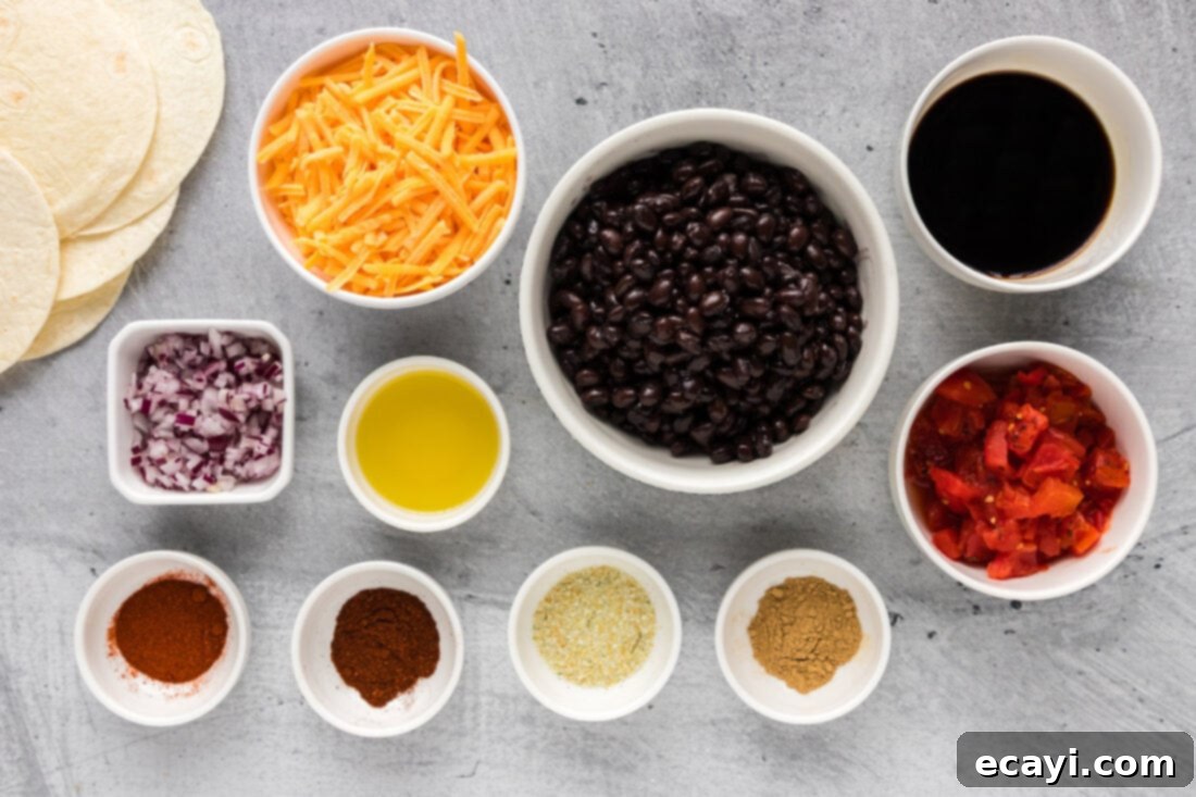 Hearty Black Bean Tacos 4 A flat lay image displaying all the fresh ingredients for Black Bean Tacos: canned black beans, red onion, diced tomatoes, tortillas, various spices, soy sauce, and shredded cheese.