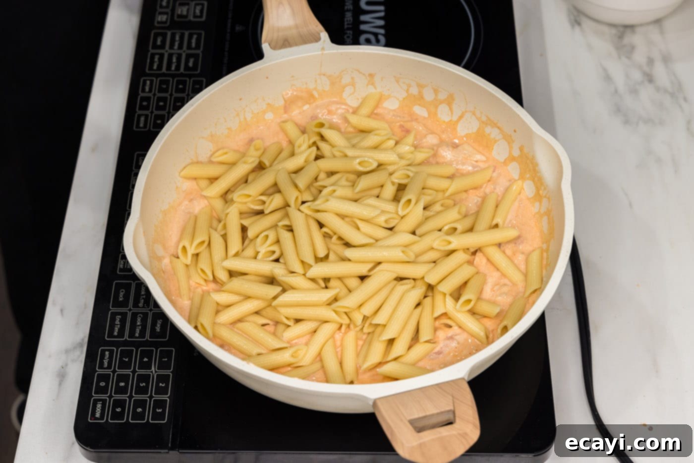 Zesty Buffalo Chicken Pasta 11 adding pasta to skillet with creamy buffalo sauce