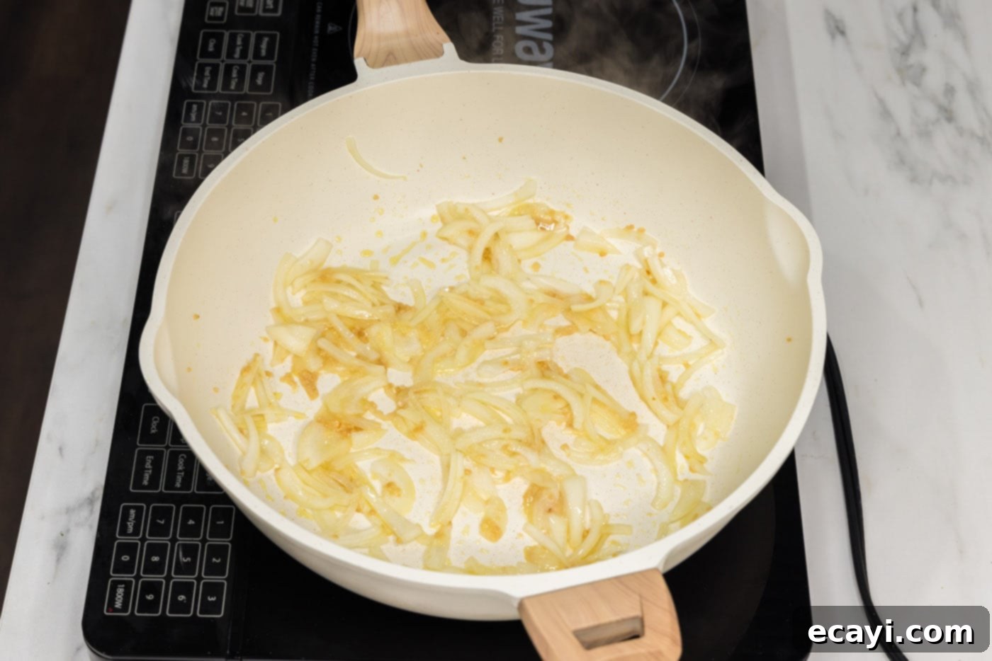 Zesty Buffalo Chicken Pasta 5 garlic and onion sautéing in a pan with oil
