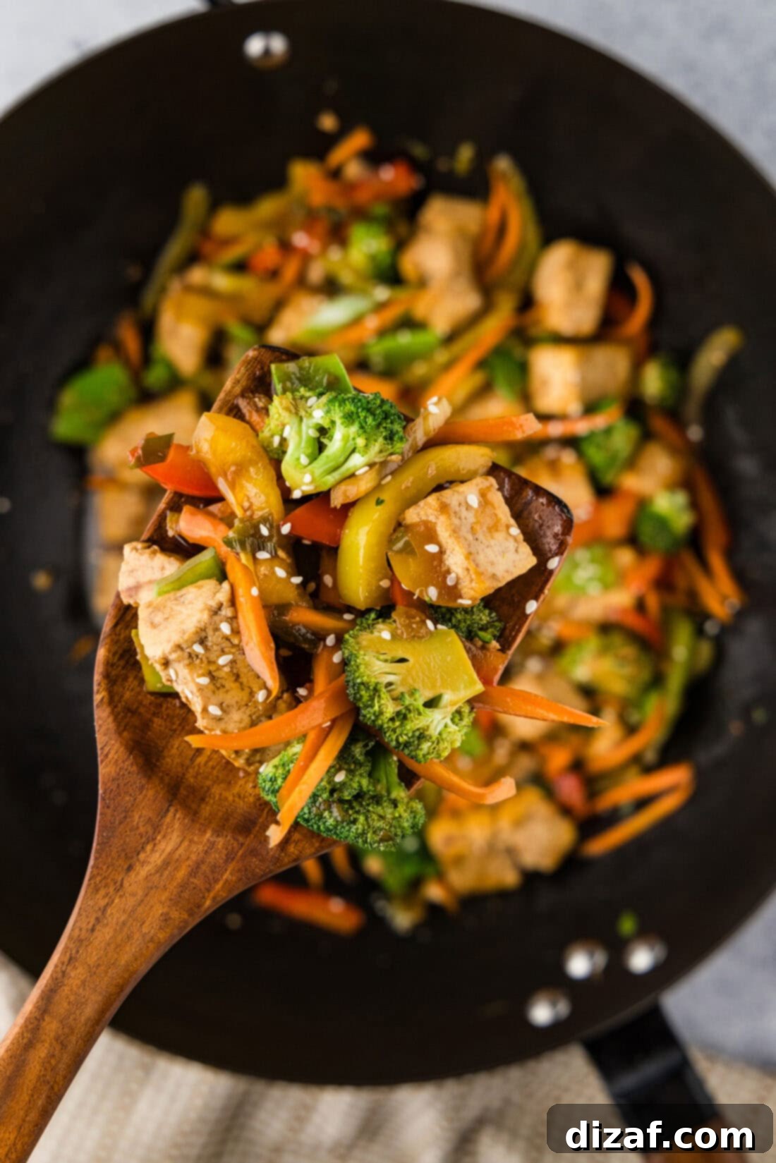 Spoonful of Tofu Stir Fry held above a wok of Tofu Stir Fry