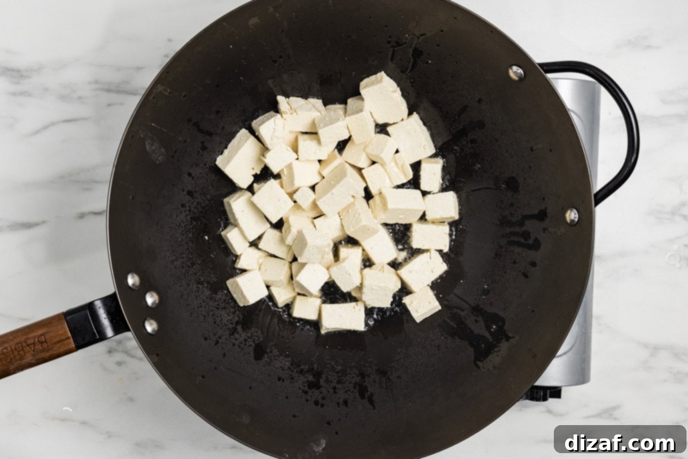 cornstarch coated tofu cubes in a wok