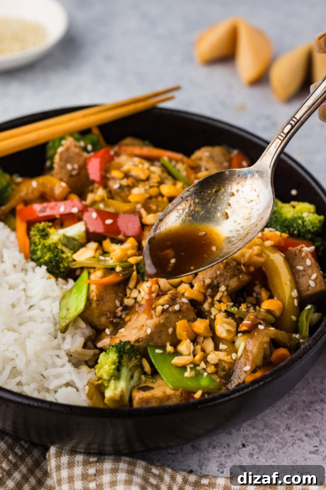 Spoon drizzling sauce over Tofu Stir Fry