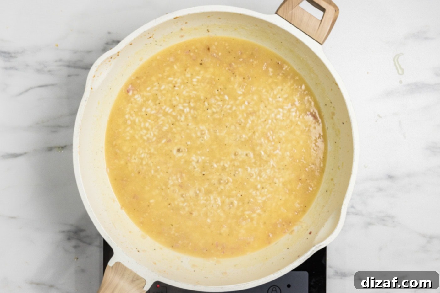 chicken broth added to skillet with risotto