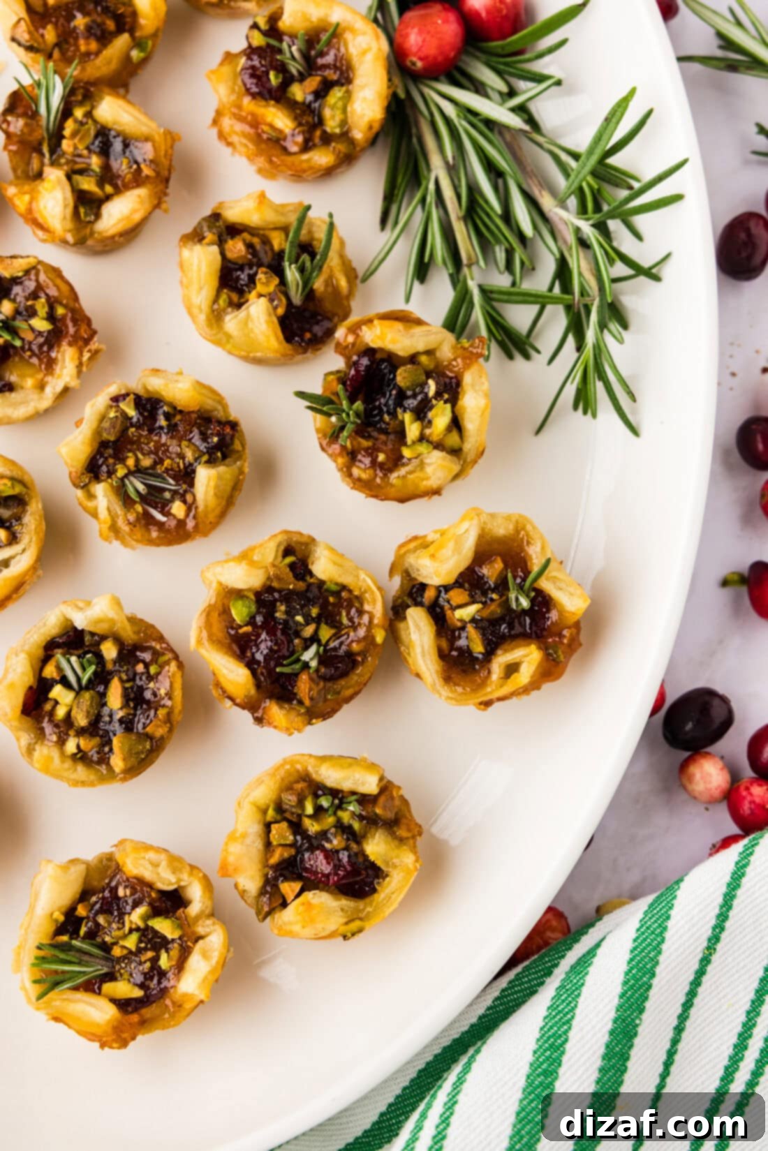 A large platter generously filled with freshly baked Brie Bites, garnished with sprigs of fresh rosemary, creating an inviting and elegant display.