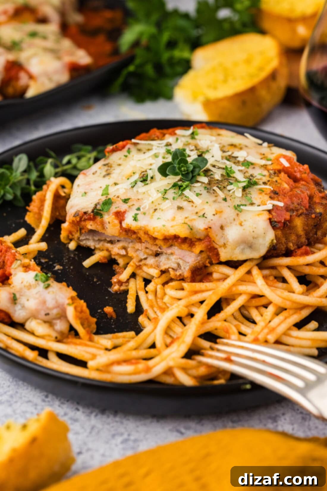 Plate of Veal Parmesan on spaghetti with a bite removed