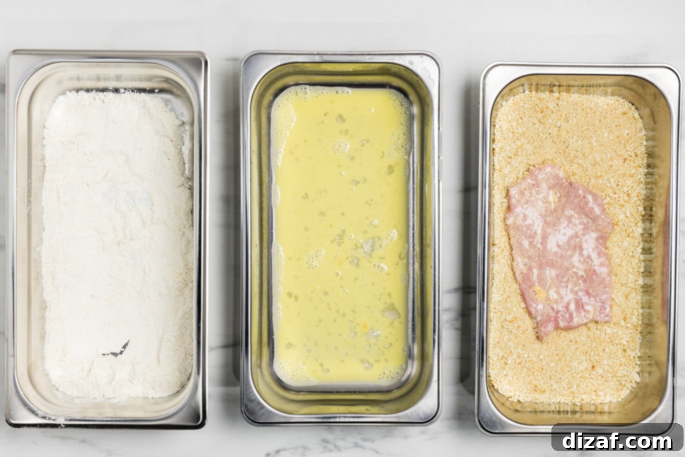 dredged veal cutlet in breading tray with panko bread crumbs