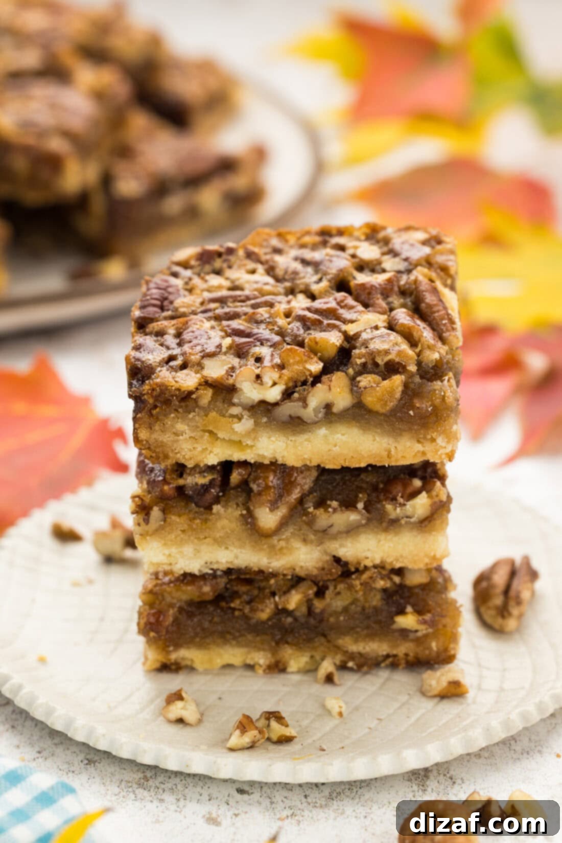 Stack of three homemade Pecan Pie Bars, highlighting their thick filling and golden crust