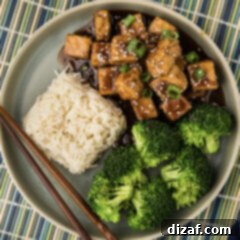 Savory Glazed Teriyaki Tofu 9 Close up photo of Teriyaki Tofu on a plate with rice and broccoli, ready to eat.