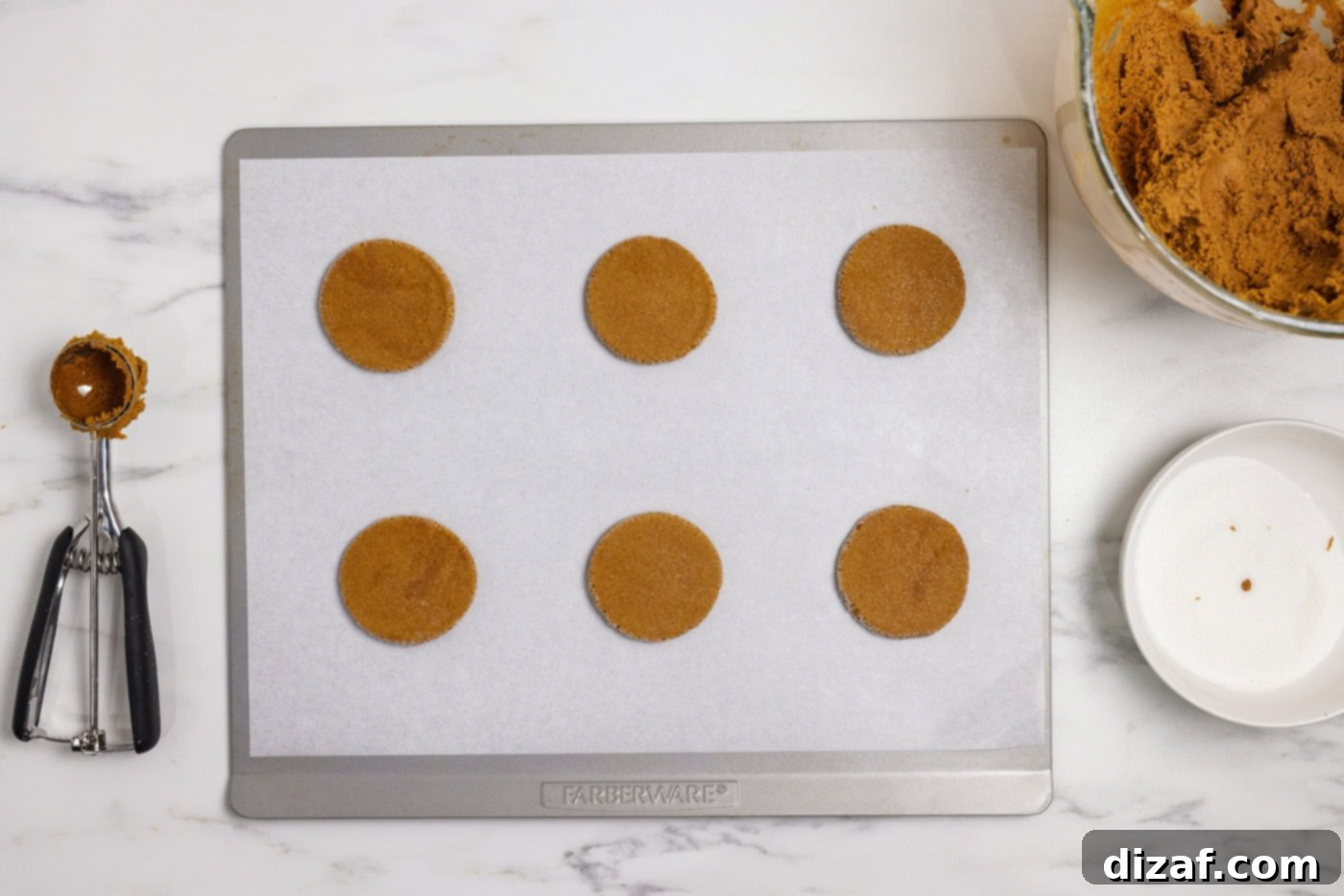 Flattened gingersnap cookie dough on a baking sheet