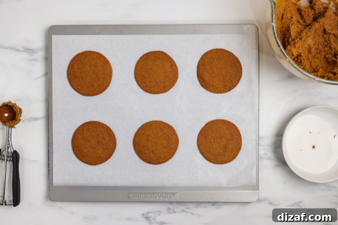 Baked crispy gingersnap cookies on a baking sheet