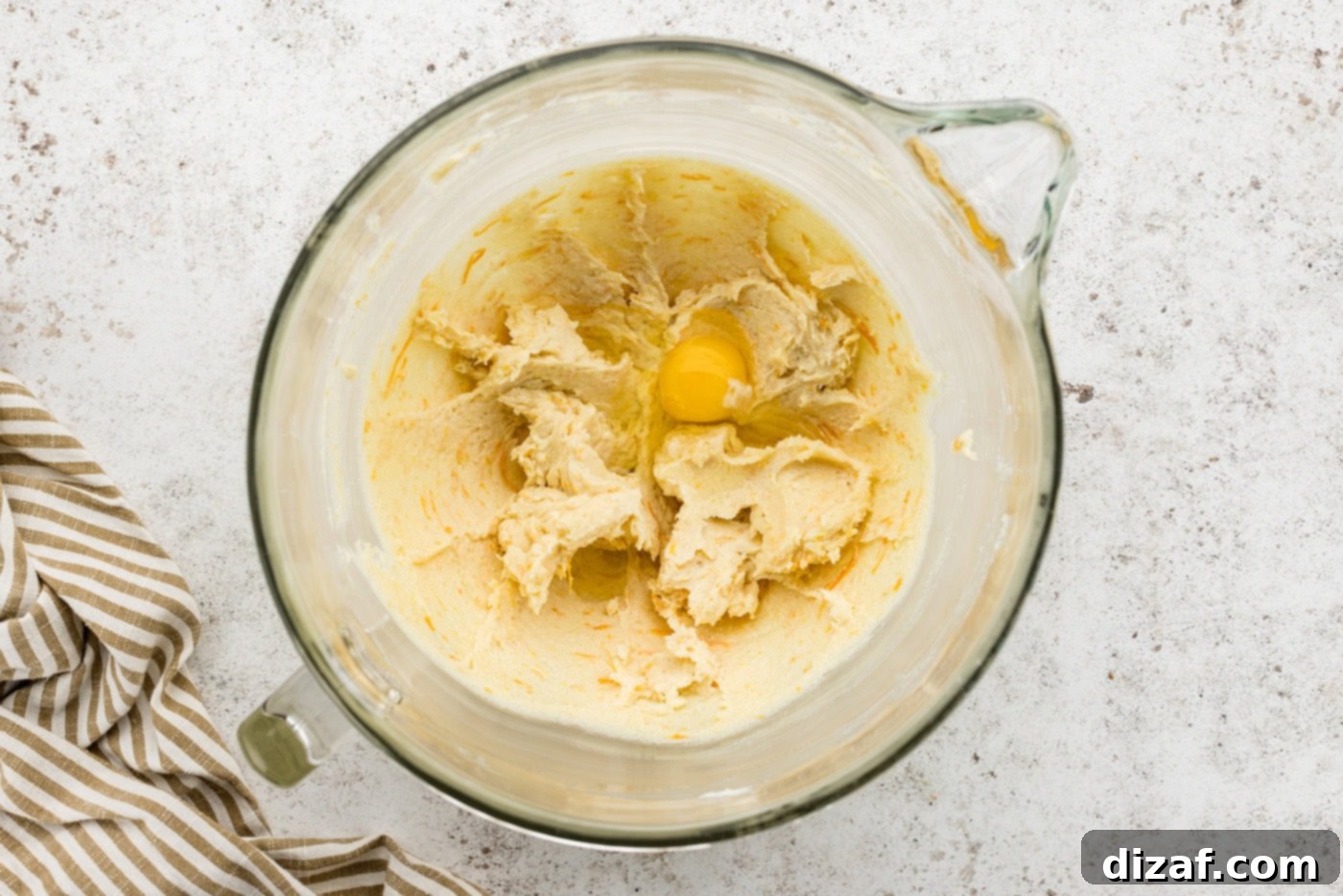 Egg added to butter and sugar mixture in stand mixer bowl