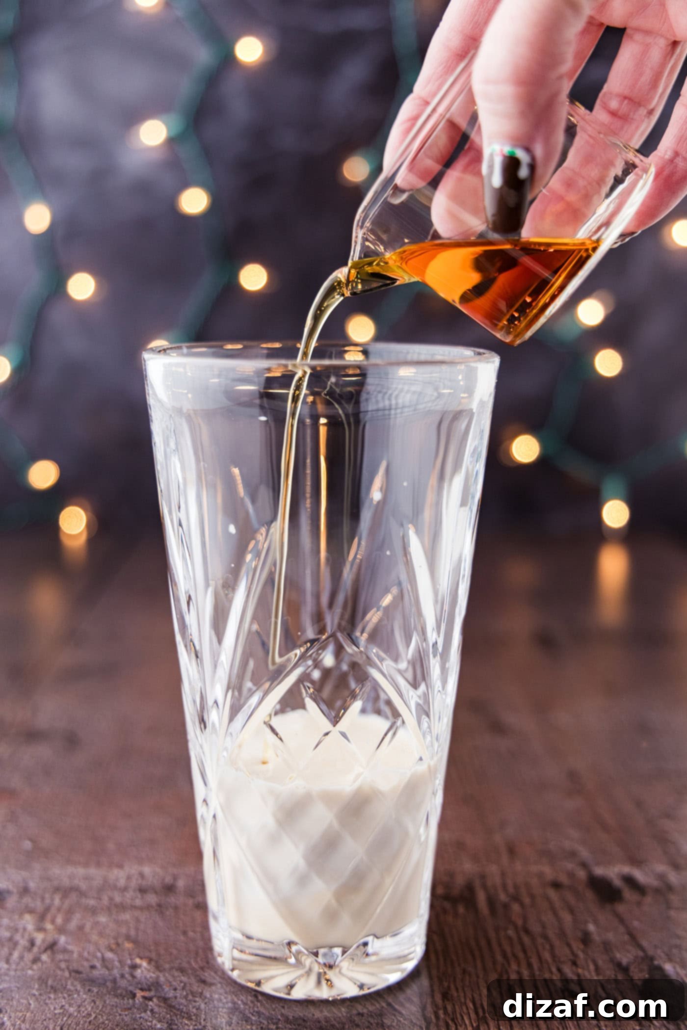 pouring amaretto into a cocktail shaker glass