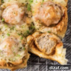 Close up photo of a Meatball Slider with a bite taken out of it, showcasing the delicious filling.