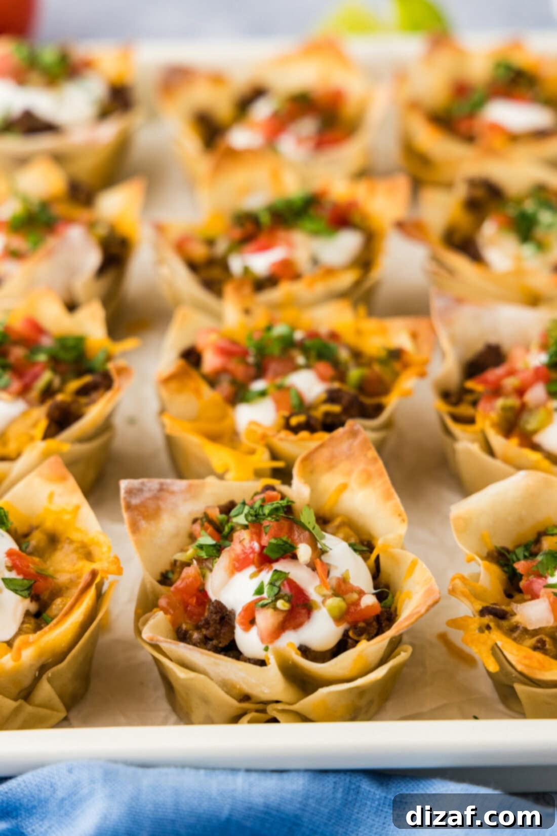 Close up photo of Taco Cups topped with sour cream and Pico de Gallo