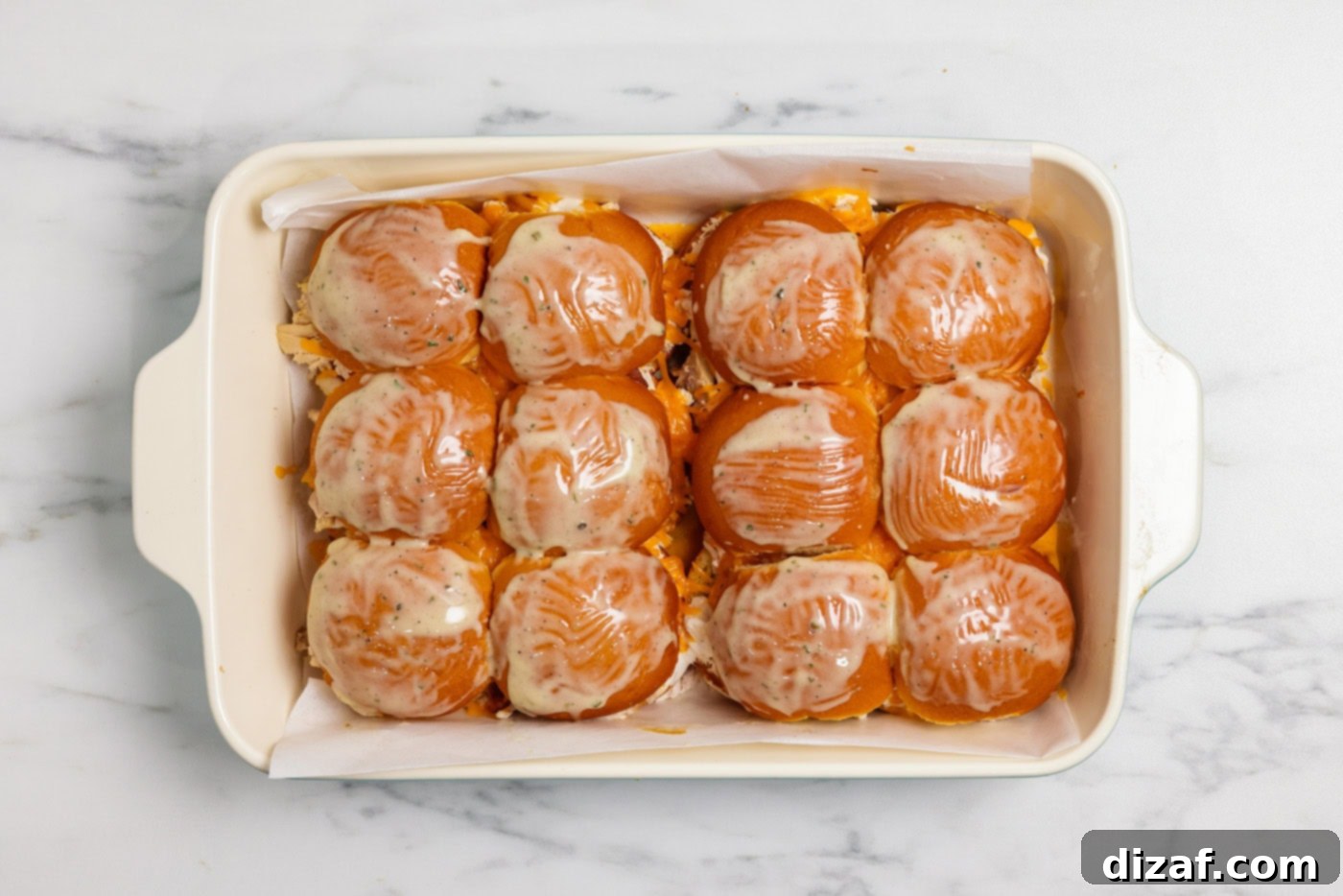 Melted butter and ranch seasoning over chicken bacon ranch sliders