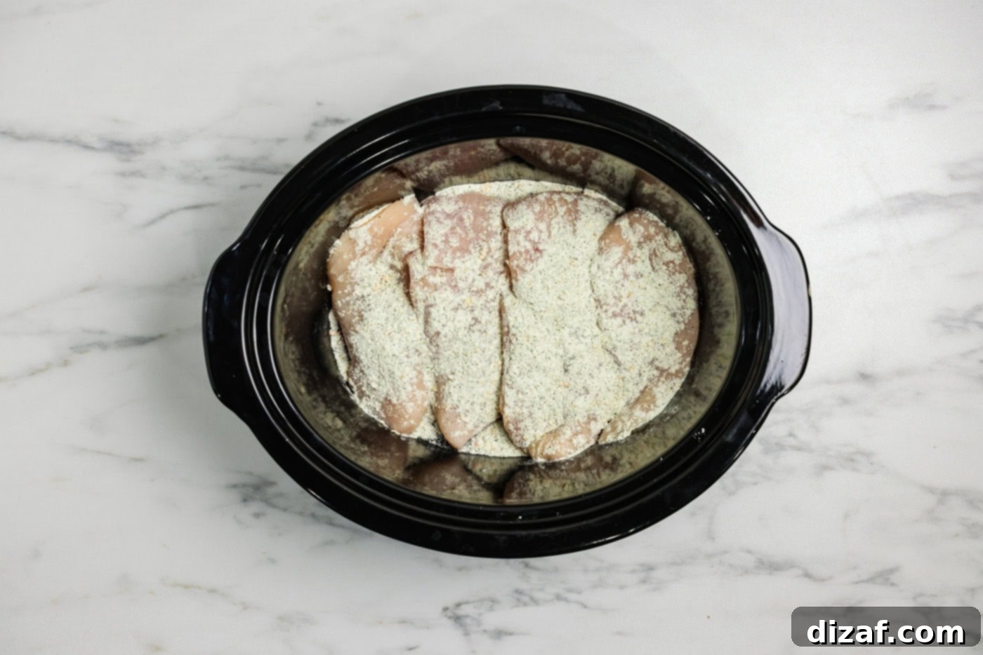 ranch seasoning srinkled over chicken breasts in a crockpot