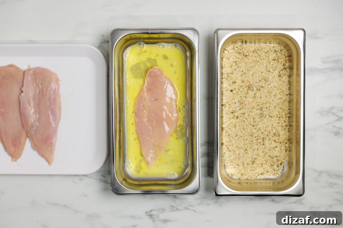 chicken breast in a breading tray with egg and water